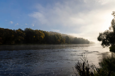 Small fog on the river in autumn, river and fog along the autumn forest