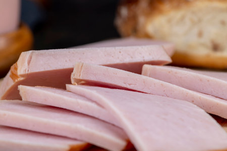 sliced piece of pork ham, slicing a finished piece of ham into small piecesの写真素材