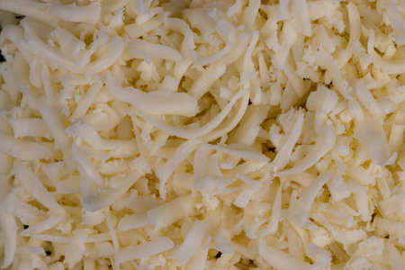 grated cheese in large quantities at home, grated cheese for cooking in the kitchenの写真素材