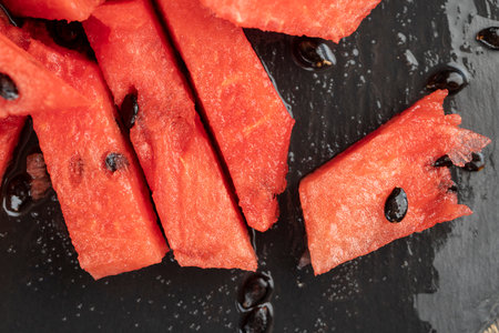sliced into pieces of red ripe watermelon, the pulp of a ripe watermelon of red color lies on the tableの写真素材