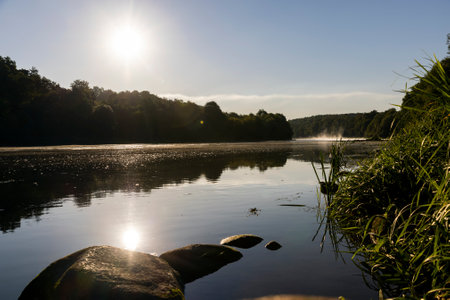 the Neman river at dawn in the autumn season, light fog on the river in the autumn season at dawnの写真素材