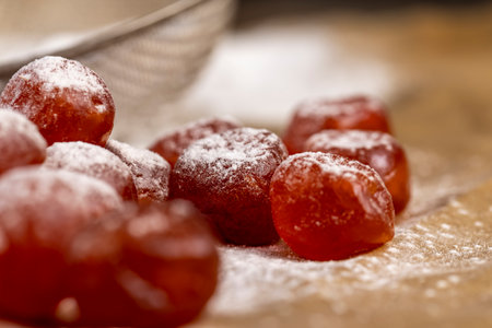 candied fruits of kumquat in sugar on paper, sweet dehydrated candied fruits of kumquat in white powdered, close upの写真素材