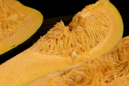 cut pumpkin with cooking seeds, orange pumpkin for cooking, pumpkin seeds inside closeupの写真素材