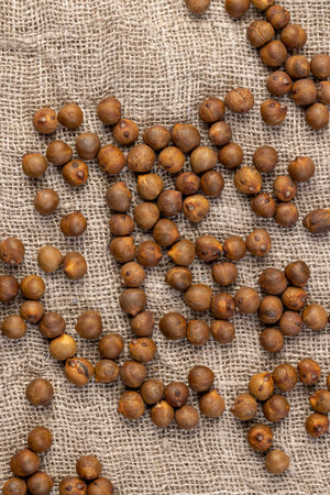 Roasted chickpeas are scattered on the table before cooking, fried but not boiled chickpeas are on...