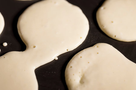 baking small pancakes with butter in a frying pan, hot metal pan while cooking pancakes with butter
