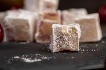 Turkish delight with cherry, cubes of sweet Turkish delight with the addition of dried red berries in powdered sugar, side viewの写真素材