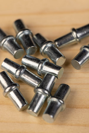 rivets for furniture are used to install shelves in cabinets, furniture metal fittings on a wooden board close upの写真素材