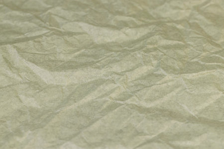 crumpled thin soft paper for packaging or other purposes, part of a sheet of paper crumpled after useの写真素材