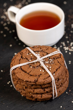 chocolate biscuits with sesame seeds on the table close up, cookies are tied with ropeの写真素材