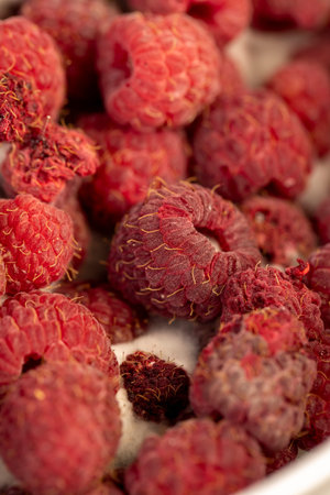 mold-covered overripe spoiled red raspberries, spoiled food products naturally grown raspberries