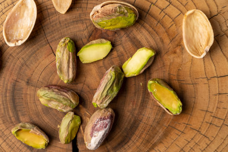 salted pistachios without shells, cut into pieces on a board, close up