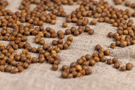 chickpeas are scattered on the tablecloth , fried but not boiled chickpeas are on the table with a linen tableclothの写真素材