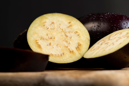 one cut eggplant, sliced ripe eggplant on the table before cooking, closeupの写真素材