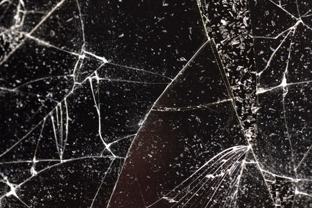 glass broken into many pieces on a black background