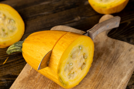Slice yellow pumpkin or zucchini, slicing ripe zucchini on a black table, close upの写真素材