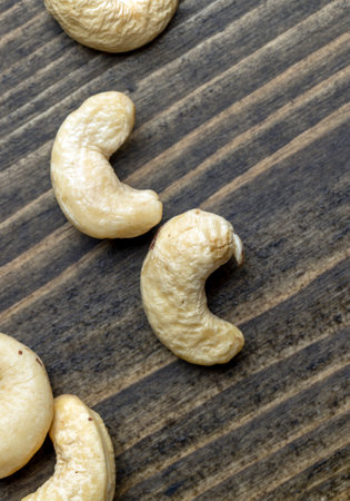 Delicious cashew nuts on a wooden surface, ready to eat and peeled cashew nutsの写真素材