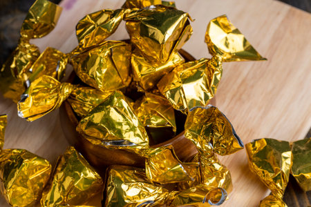 Packed in golden foil truffle candy on the board, a large number of chocolates with cocoa in the packageの写真素材