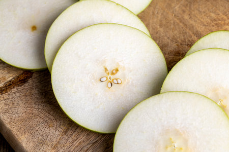 Sliced ripe green pear, pieces of ripe pear on a black tableの写真素材