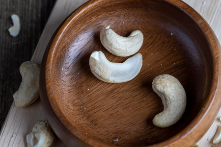 Hard roasted and peeled cashew nuts on the table, delicious cashew nuts on a wooden surfaceの写真素材