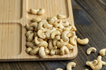 Delicious cashew nuts on a wooden surface, ready to eat and peeled cashew nuts