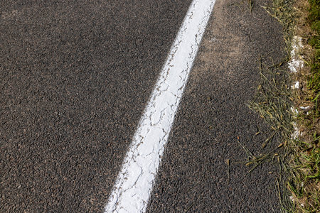 Paved highway with white road markings, traffic regulation using lines on asphaltの写真素材