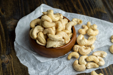 Delicious cashew nuts on a wooden surface, ready to eat and peeled cashew nutsの写真素材