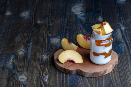 Yogurt made from fresh milk with the addition of sweet peach jam and fresh peaches, delicious yogurt with peach flavorの写真素材
