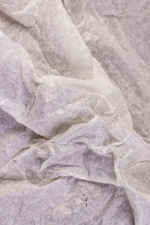 crumpled light-colored wrapping paper after prolonged use, thin paper made of cellulose as a...