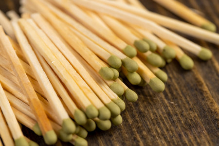 matches scattered in a large pile, a large number of thin wooden matches with a head, close up, side...