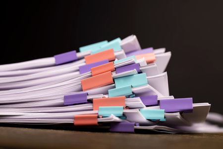 a large number of white blank sheets of paper are connected by multicolored metal clips, stacked sheets of paper for documents are joined togetherの写真素材