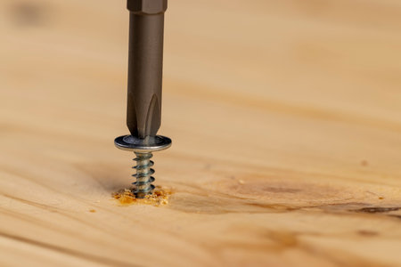 pine board and steel screws, silver self-tapping screws for wood on the board, close upの写真素材