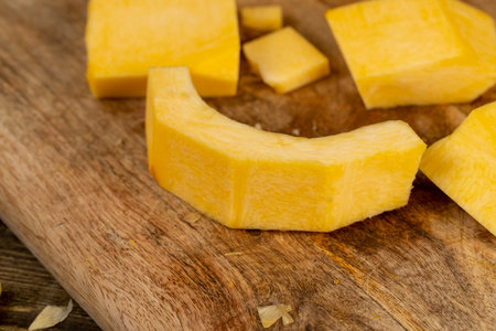 orange pumpkin cut into pieces, preparing the pumpkin for cooking by cutting into pieces, side viewの写真素材
