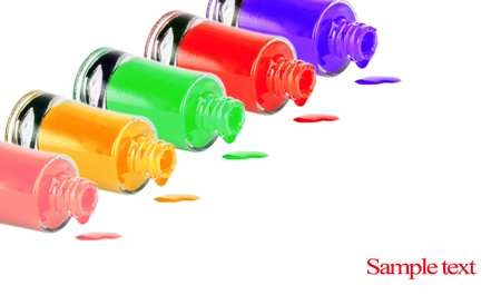 Bottles with spilled nail polish over white background の写真素材