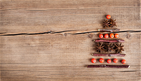 Christmas card with natural decorations on wooden background. Set of different varieties of objects in the form of a tree. Winter holidays conceptの写真素材