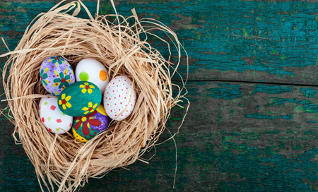 Easter eggs in nest on rustic wooden planks. Holidays background