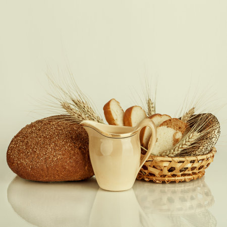 Fresh bread and wheat on the wooden table. Food background