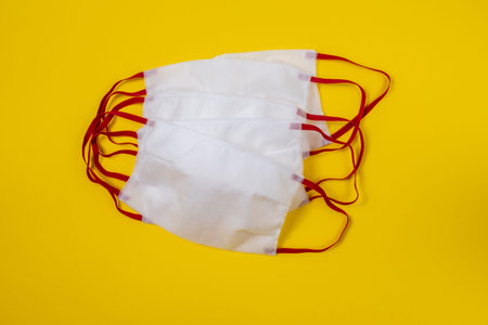 Medical protective mask on yellow background. Disposable surgical face mask cover the mouth and nose...