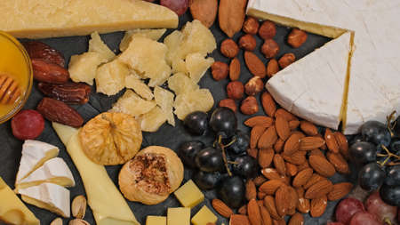 Cheese platter with various types of cheese - parmesan brie roquefort camembert maasdam. Gourmet appetizer, snack food. Assortment of various Spanish french Italian appetizers. cheese plateの写真素材
