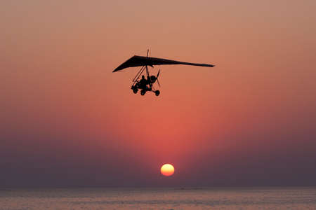 The person flying on a hang-glider with the motor against a decline.の写真素材