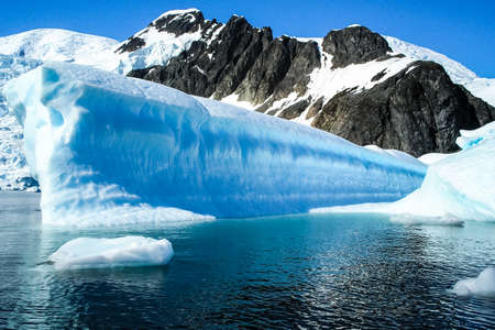 The landscape of the coast of Antarctica, Mountains covered with snow and ice-cold ocean.の写真素材