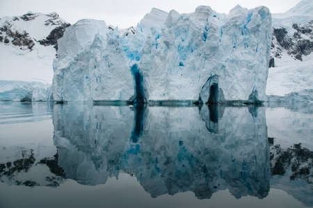 The landscape of the coast of Antarctica, Mountains covered with snow and ice-cold ocean.の写真素材