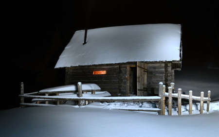 Winter landscape with snow-covered hut in the forest in the mountainsのeditorial素材