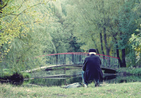 Retirees fishes in nature (loneliness, old age, pension - concept)の写真素材