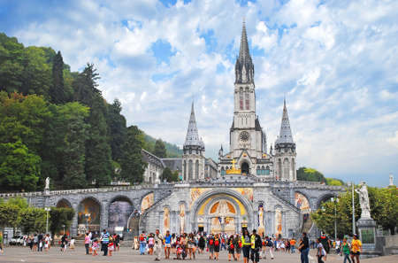 LOURDES â AUGUST 23: Christian cross on a background the Basilica of our Lady of the Rosary on August 23, 2011 in Lourdes, (France).のeditorial素材
