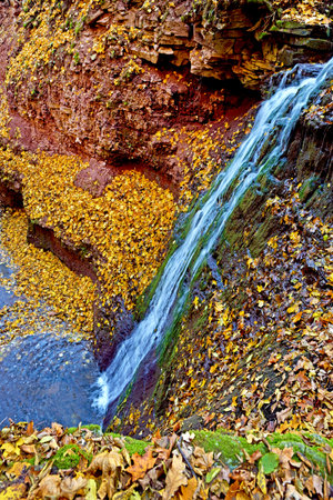 Magical view high waterfall on the rocks in autumn with yellow leaves. (Harmony, peace, meditation -...