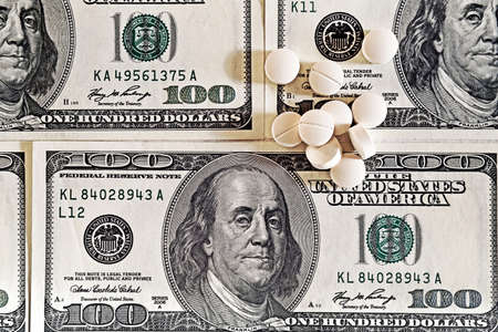 Tablets on dollar bills (treatment, addiction, aging - concept). Vintage effect.の写真素材