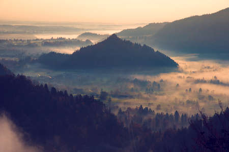 mystical landscape with fog in the valley in the mountainsの写真素材