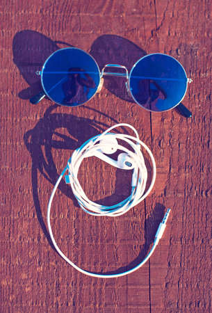 Headphones folded in the shape of smiley face with sunglassesの写真素材