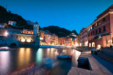 Magical panorama landscape with boats in the bay and colored houses on the rock in Vernazza, Cinque Terre, Italy, Europe at nightの写真素材