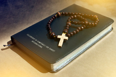 A wooden rowan on a black leather bible that shifts the light
